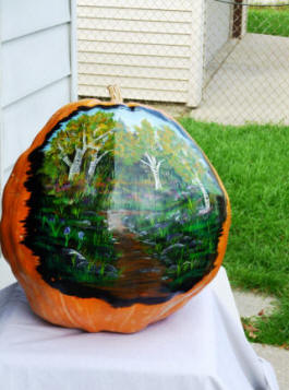 Large Pumpkin with a painted scene with a lot of green.