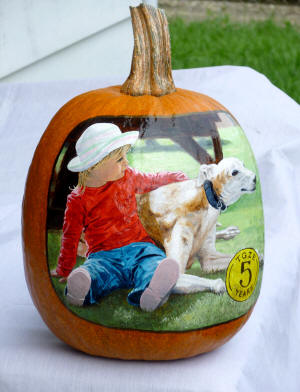 Child witha a dog painted on a pumpkin