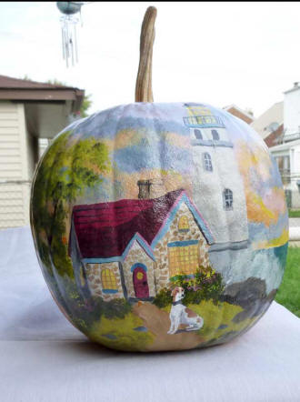 Dog infront of a house scene painted on a pumpkin