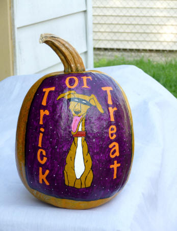 Treat or tret cartoon of a greyhound paintd on  a pumpkin